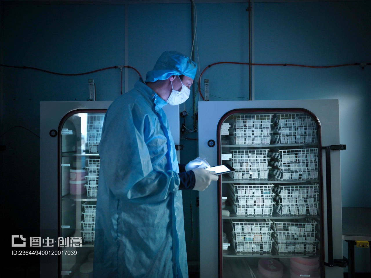 Worker using digital tablet to check archived electronic components in nitrogen atmosphere in clean room laboratory